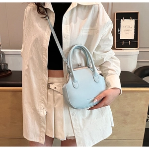 Detail of light blue vintage frame bag with gold clasp and elegant leather top handles