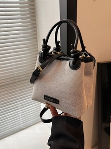 Minimalistische Stroh-Eimertasche mit schwarzem Lederbesatz und verstellbarem Riemen