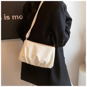 Primer plano del bolso nube plisado crema con textura suave y correa de hombro