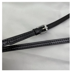 Detail of black glossy leather strap with silver metal buckle and neat tonal stitching