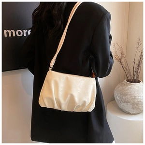 Detalle de un bolso nube plisado beige crema en cuero PU suave con una correa delgada