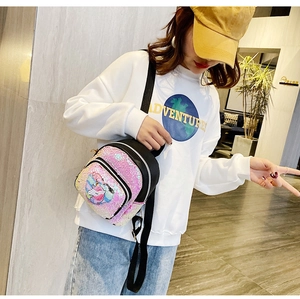 Dettaglio dello zaino mini con paillettes rosa e unicorno indossato da una modella casual