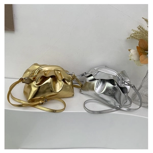 Detail of metallic pleated cloud bags in gold and silver with drawstring shoulder straps