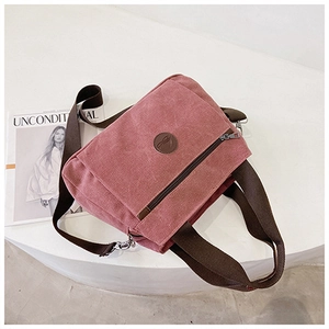 Dettaglio della borsa a tracolla in tela rosa con tasca a cerniera su supporto bianco