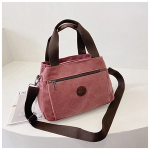 Vista dettagliata della borsa in tela rosa con tasca a zip e tracolla regolabile morbida