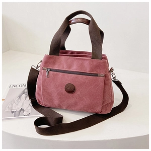 Dettaglio della borsa in tela rosa con trama spessa e design a scomparti multipli