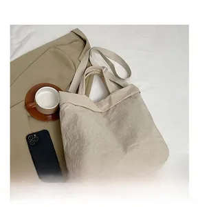 Vue détaillée du sac cabas en nylon beige avec texture plissée et sangle réglable