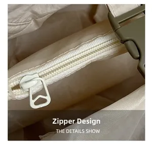 Détail de la fermeture éclair blanche et de la boucle en plastique vert du sac à dos