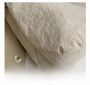 Gros plan des coutures précises et du nylon froissé sur un sac beige en bandoulière