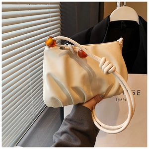 Detalle del bolso nube crema con cuentas de ámbar y textura de cuero fruncido suave