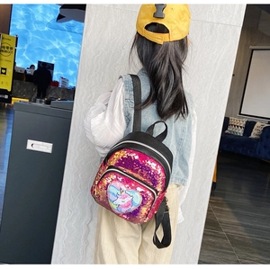 Ragazza indossa uno zainetto mini con unicorno e paillettes magenta con ricamo