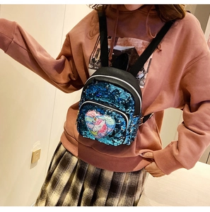 Dettaglio dello zainetto con paillettes blu scintillanti e patch cuore di unicorno