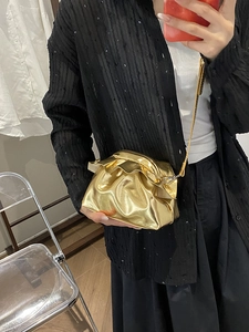 Metallic gold pleated cloud bag with elegant ruffle edge and sleek metal chain strap