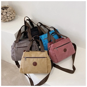 Dettaglio di borse in tela multicolore con diversi cinturini e tasche frontali con zip