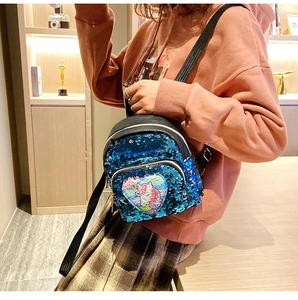 Dettaglio del mini zaino con paillettes blu, toppa a cuore con unicorno e spalline nere