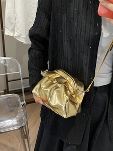 Metallic gold cloud crossbody bag with pleated texture and slender metal strap