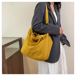 Détail du grand sac cabas jaune vif montrant la texture en nylon et les bandoulières