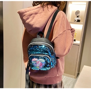 Dettaglio dello zaino con paillettes blu lucide con toppa a forma di cuore con unicorno