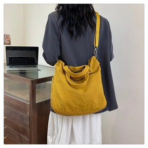 Vue détaillée d'un grand sac cabas jaune avec bandoulière réglable sur le modèle