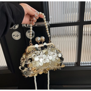 Detailed shot of sequin evening bag with pearl handle and bead clasp for gala attire