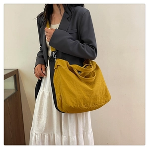 Détail du sac cabas jaune moutarde montrant la texture douce et la bandoulière amovible