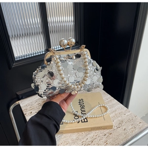 Detail view of silver sequin evening bag with gold metal frame and pearl handle chain