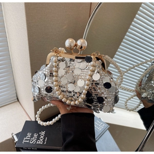 Detail of silver sequined evening bag featuring pearl handle and golden frame