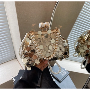 Macro shot of gold sequin evening clutch bag with large pearl handle and metal clasp