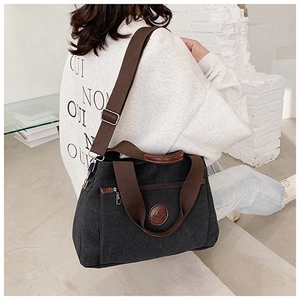 Borsa tote casual in tela nera con cinturini marroni mostrata su una modella