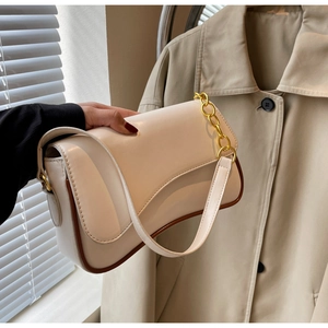 Detail van de roomwitte vintage tas met gouden ketting en donkerbruine biezen details