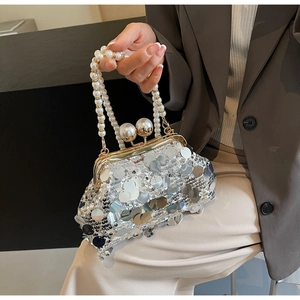 Close-up of silver sequin evening bag with large pearl clasp and bead handle
