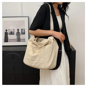 Détail d'un grand sac fourre-tout crème en tissu souple pour les trajets quotidiens