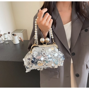 Close-up of silver sequin shoulder bag with white pearl handle and elegant metal clip