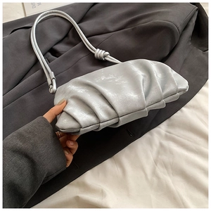 Detalle del bolso nube plateado plisado con acabado metálico y correa anudada