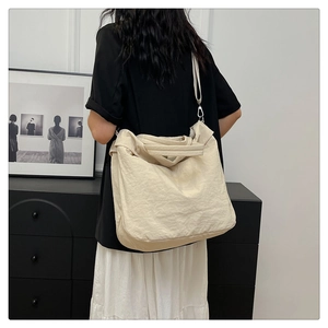 Vue arrière détaillée d'un grand sac cabas en toile beige avec de larges bretelles et texture douce