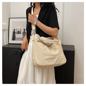 Détails du grand sac cabas beige avec texture en tissu souple et large bandoulière