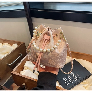 Detail of pink jacquard bucket bag with pearl handle and delicate floral embroidery