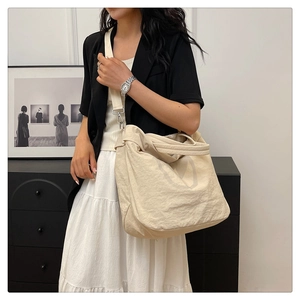 Détail du grand sac bandoulière en nylon avec motif en V et crochets en métal argenté