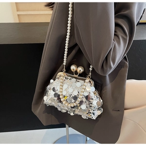 Close-up of silver sequin evening bag featuring large pearls and a clasp closure