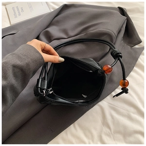 Detalle de bolso nube negro con cuentas de ámbar y bolsillo interior con cremallera