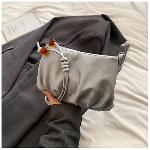 Detalle del bolso nube plisado plateado con cuentas de ámbar y textura metálica