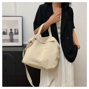 Vue détaillée du sac cabas beige en tissu froissé porté à l'épaule par un mannequin