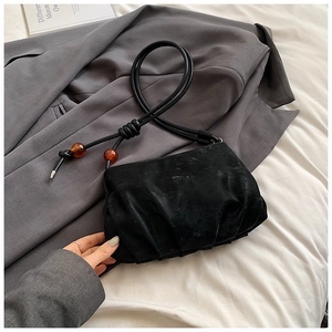 Detalle del bolso nube de terciopelo negro con cuentas de ámbar y correa anudada