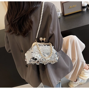Close-up of silver sequin evening bag with large pearl clasp and pearl chain strap