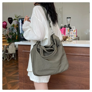 Détail du sac fourre-tout en nylon olive foncé avec texture souple et boucles métalliques