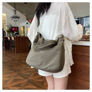 Détail d'un grand sac cabas vert olive montrant sa texture en nylon souple et sa taille