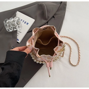 Detail of pink bucket bag with gold embroidery, white pearls, and inner pocket