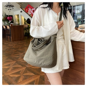 Vue détaillée du grand sac hobo en toile vert olive avec large bandoulière en tissu