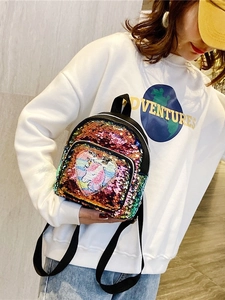 Mini zaino unicorno con paillettes iridescenti e toppa a cuore su una modella elegante