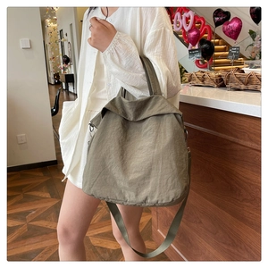 Détail du grand sac cabas en toile vert olive avec bandoulière réglable et texture plissée